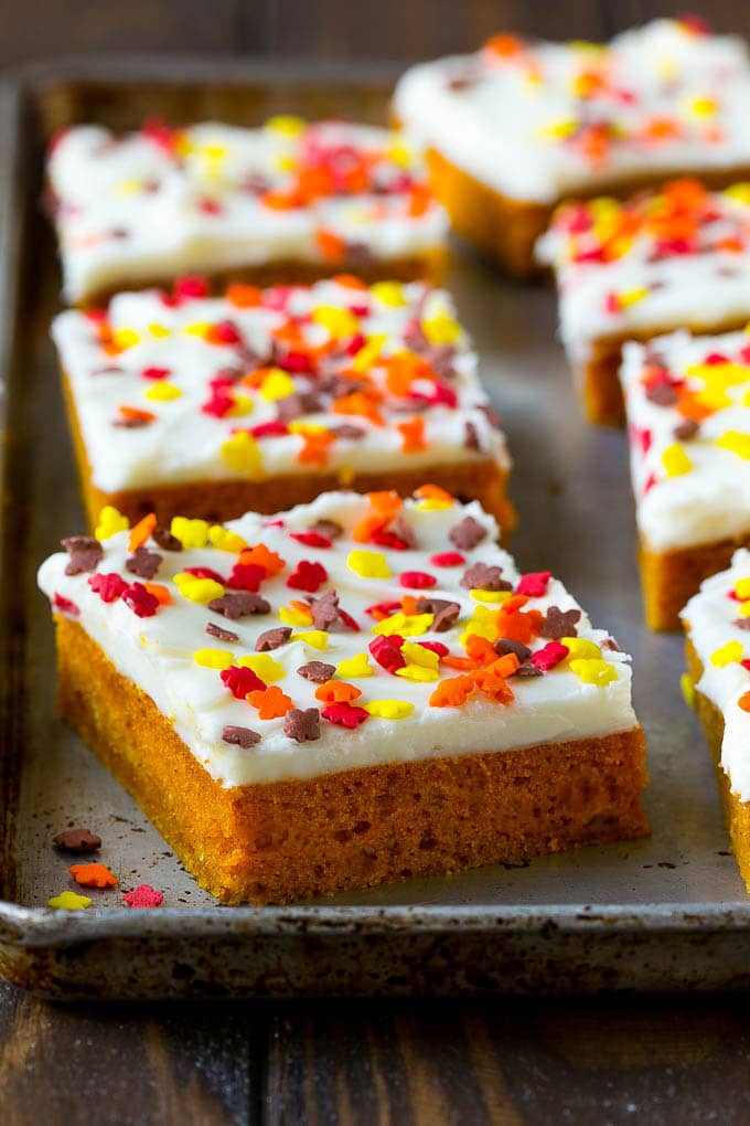 Pumpkin Bars Recipe | Pumpkin Cake | Pumpkin Dessert #pumpkin #fall #dessert #fuyos #thanksgiving A baking sheet of frosted pumpkin bars.