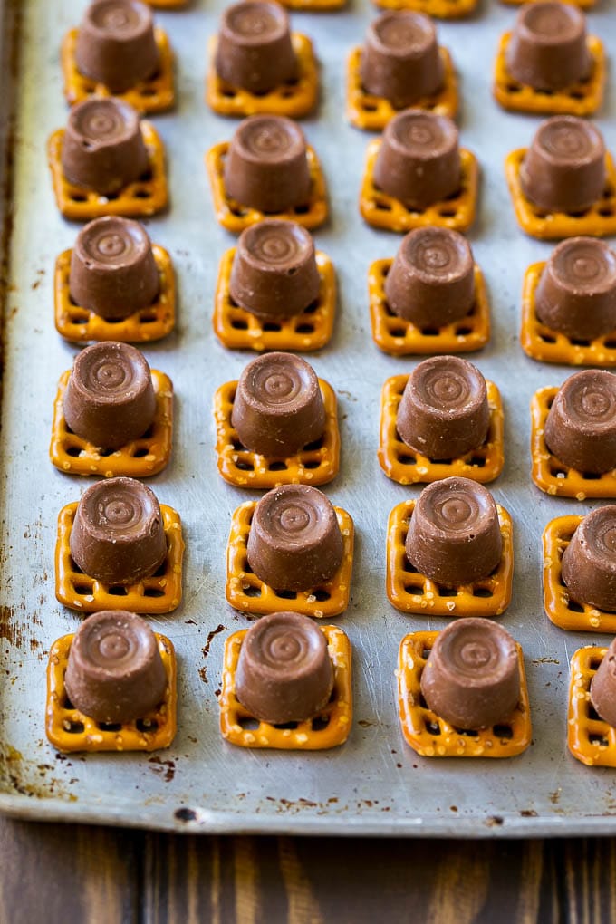 Rolo Pretzels Recipe | Chocolate Pretzels | Caramel Pretzels | Holiday Candy #christmas #baking #dessert #candy #chocolate #caramel #pretzels #fuyos Squares with candies on top.
