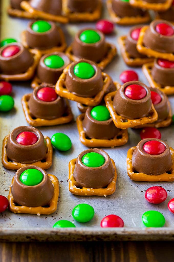 Rolo Pretzels Recipe | Chocolate Pretzels | Caramel Pretzels | Holiday Candy #christmas #baking #dessert #candy #chocolate #caramel #pretzels #fuyos Rolo pretzels on a baking sheet topped with red and green M&M's.