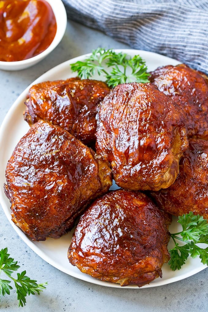 Smoked Chicken Thighs Recipe | Barbecue Chicken Thighs | Easy Chicken Thighs #chicken #barbecue #smoker #dinner #fuyos A plate of smoked chicken thighs coated in spice rub and barbecue sauce.