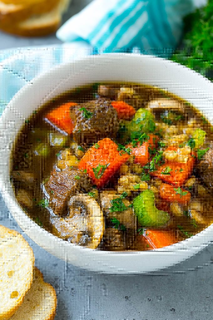 Beef Barley Soup Recipe | Beef Soup | Barley Soup #soup #beef #dinner #vegetables #fuyos #comfortfood A bowl of beef barley soup topped with chopped parsley.