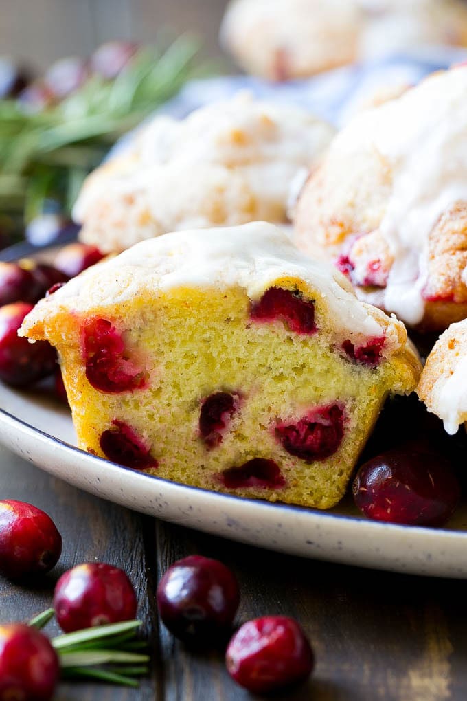 Cranberry Muffins Recipe | Cranberry Orange Muffins #cranberry #muffins #orange #fall #dessert #fuyos A plate of muffins with one cut in half.