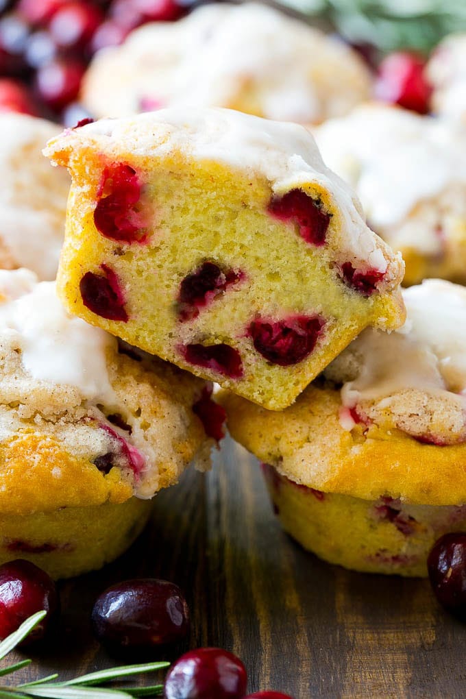 Cranberry Muffins Recipe | Cranberry Orange Muffins #cranberry #muffins #orange #fall #dessert #fuyos A stack of cranberry muffins with one muffin cut in half.