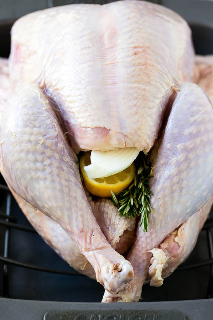 Roast Turkey Recipe | Thanksgiving Turkey | Holiday Turkey | Baked Turkey #turkey #thanksgiving #christmas #dinner #glutenfree #fuyos A raw bird with onion, lemon and herbs in the cavity.