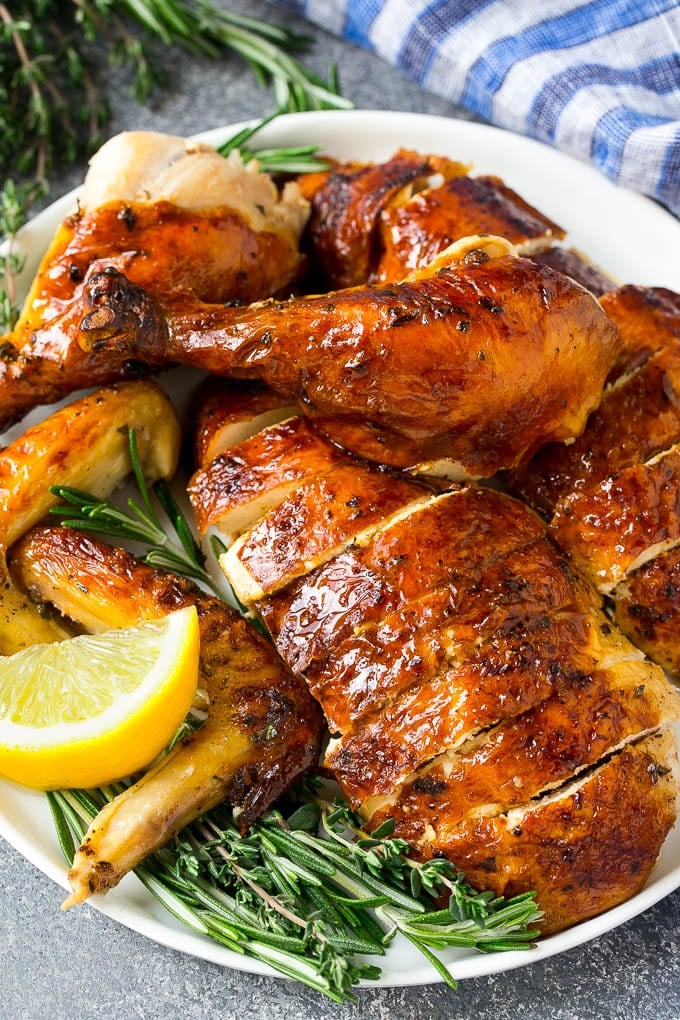 Roasted Chicken Recipe | Whole Roasted Chicken | Roast Chicken #chicken #dinner #lowcarb #keto #fuyos Carved roasted chicken on a serving platter with fresh herbs.