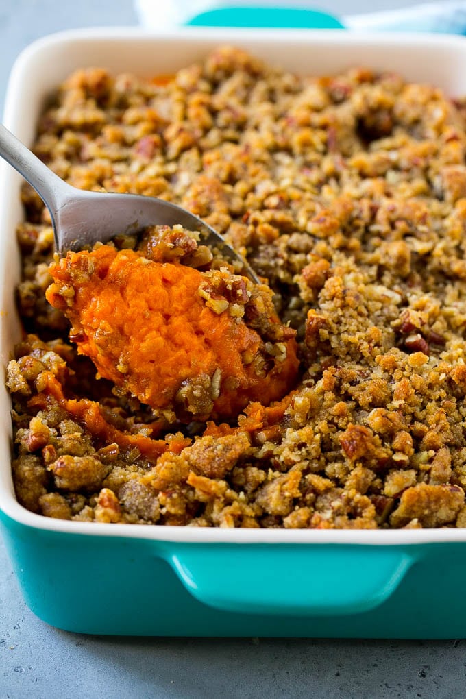 Ruth's Chris Sweet Potato Casserole Recipe | Sweet Potato Casserole | Mashed Sweet Potatoes #sweetpotatoes #casserole #thanksgiving #christmas #holidays #dinner #fuyos #sidedish Ruth's Chris sweet potato casserole with a serving spoon in it.