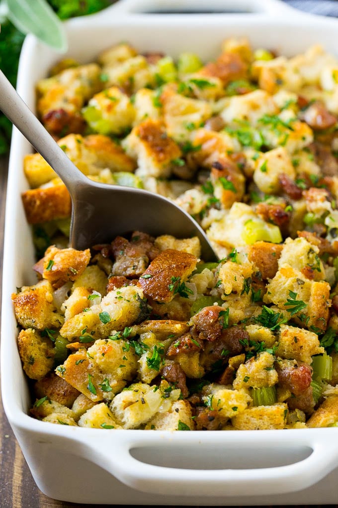 Sausage Stuffing Recipe | Thanksgiving Stuffing | Make Ahead Stuffing #stuffing #thanksgiving #sausage #sidedish #dinner #fuyos A baking dish of sausage stuffing with a serving spoon in it.