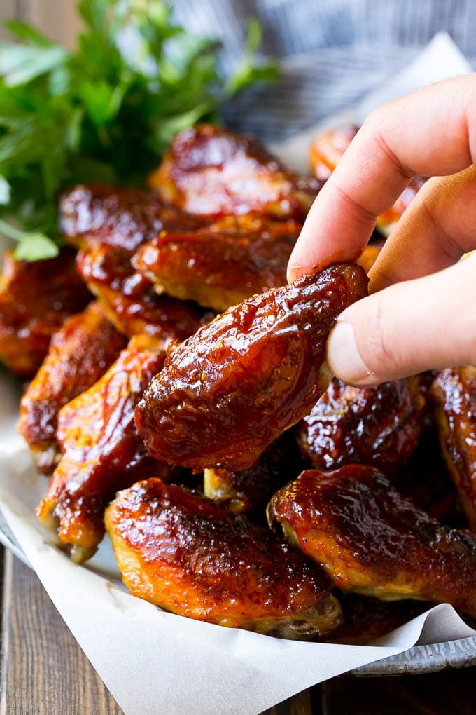 Smoked Chicken Wings | Barbecue Chicken Wings | BBQ Chicken Wings #chicken #wings #bbq #barbecue #appetizer #dinner #fuyos A pile of smoked chicken wings with a hand reaching out for one.
