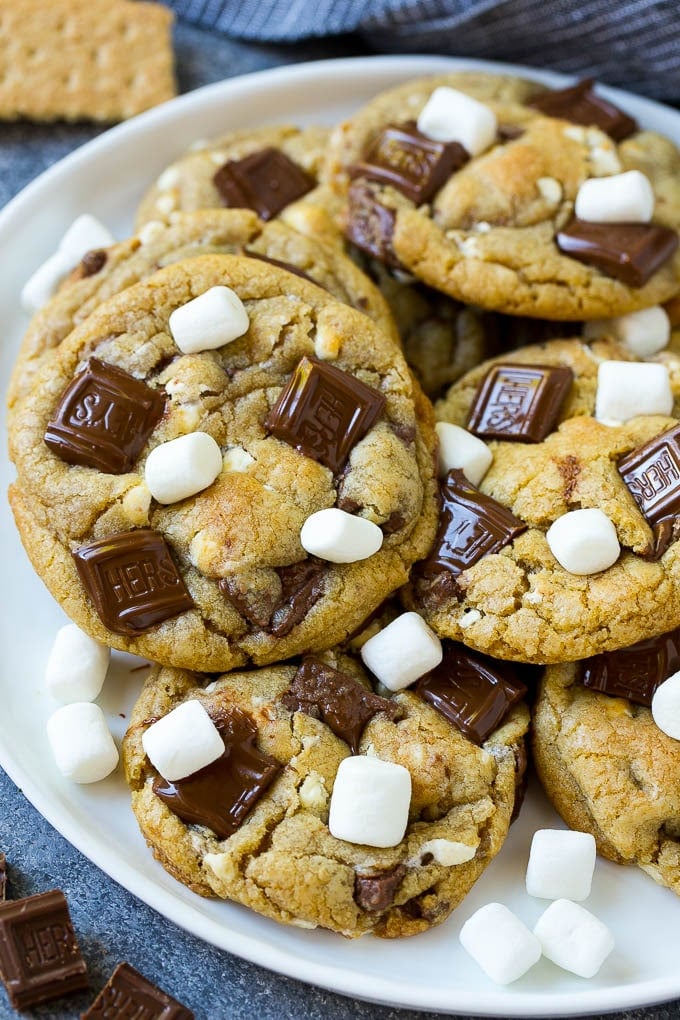 S'mores Cookies Recipe | Marshmallow Cookies #smores #marshmallow #chocolate #cookies #dessert #fuyos A plate of S'mores cookies topped with milk chocolate bars and marshmallows.