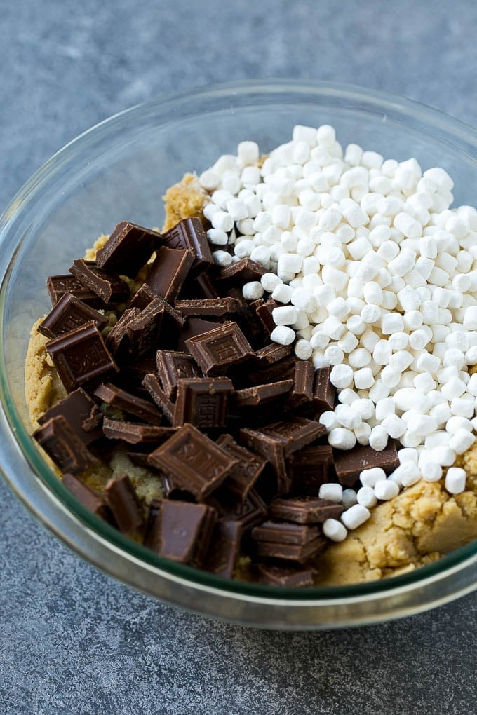 S'mores Cookies Recipe | Marshmallow Cookies #smores #marshmallow #chocolate #cookies #dessert #fuyos Graham cracker cookie dough with marshmallow bits and milk chocolate.