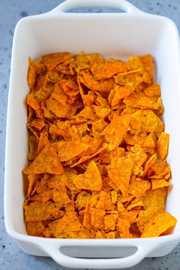 Dorito Casserole Recipe | Mexican Casserole | Beef Casserole #mexicanfood #beef #groundbeef #casserole #dinner #fuyos Crushed nacho chips in the bottom of a casserole dish.