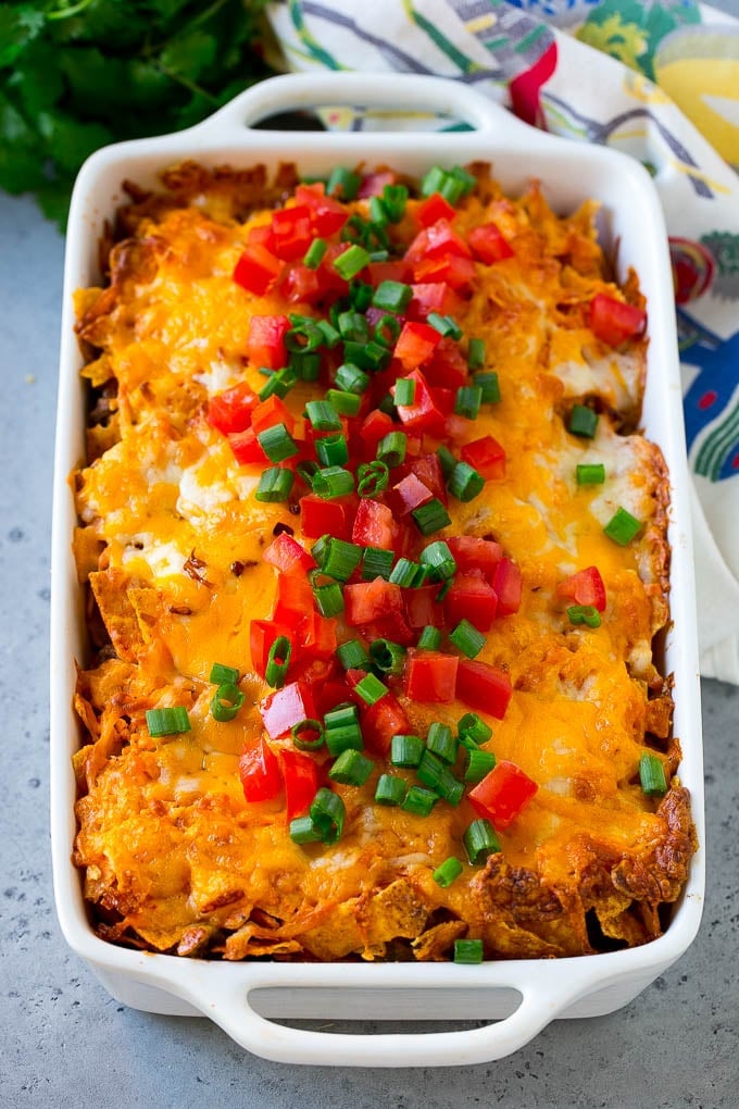 Dorito Casserole Recipe | Mexican Casserole | Beef Casserole #mexicanfood #beef #groundbeef #casserole #dinner #fuyos Dorito casserole topped with melted cheese, diced tomatoes and sliced green onions.