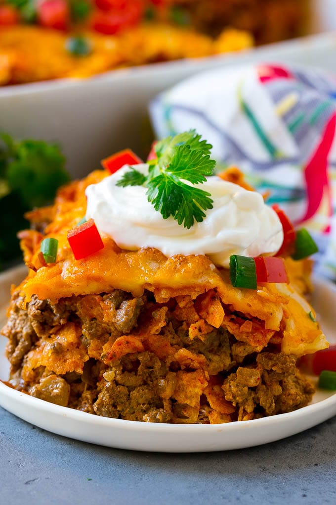 Dorito Casserole Recipe | Mexican Casserole | Beef Casserole #mexicanfood #beef #groundbeef #casserole #dinner #fuyos A piece of Dorito casserole with layers of tortilla chips, beef and cheese.