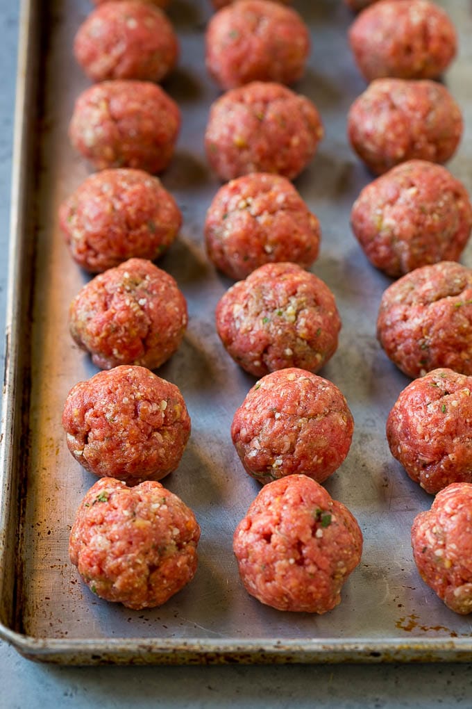 Italian Meatball Soup Recipe | Meatball Soup | Beef Meatballs #meatballs #beef #soup #italian #dinner #fuyos #comfortfood Raw meatballs on a sheet pan ready to go into the oven.