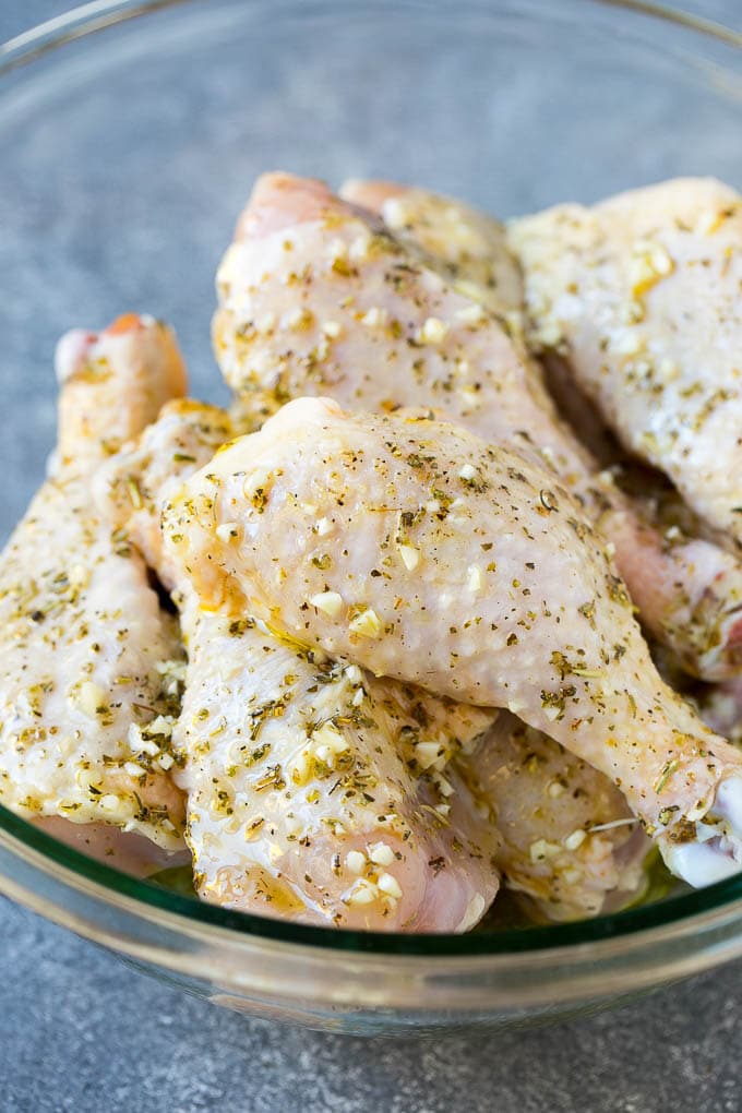 Baked Chicken Drumsticks Recipe | Roasted Chicken Drumsticks | Garlic and Herb Chicken #dinner #chicken #garlic #glutenfree #lowcarb #keto #cleaneating #fuyos A bowl of chicken legs in a garlic and herb marinade.