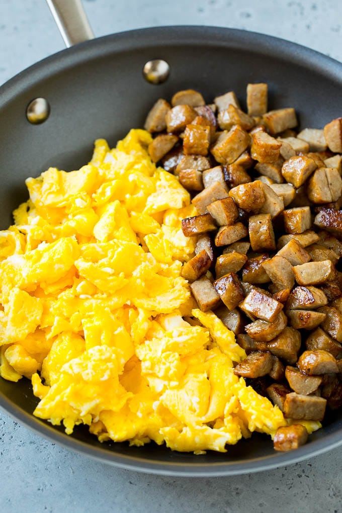 Breakfast Burrito Recipe | Sausage Breakfast Burrito #breakfast #sausage #eggs #burrito #fuyos Diced sausage and scrambled eggs in a pan.