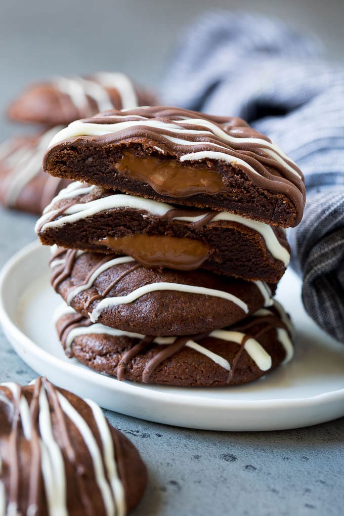 Nutella Cookies Recipe | Nutella Stuffed Cookies | Chocolate Cookies #nutella #chocolate #cookies #baking #dessert #fuyos A stack of Nutella cookies on a plate with one cut open.