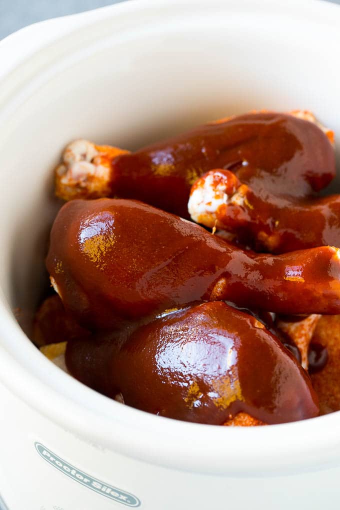 Slow Cooker Chicken Drumsticks Recipe | Crock Pot Chicken Drumsticks | BBQ Chicken Drumsticks #chicken #drumsticks #slowcooker #crockpot #bbq #dinner #fuyos A crock pot of chicken drumsticks coated in BBQ sauce.