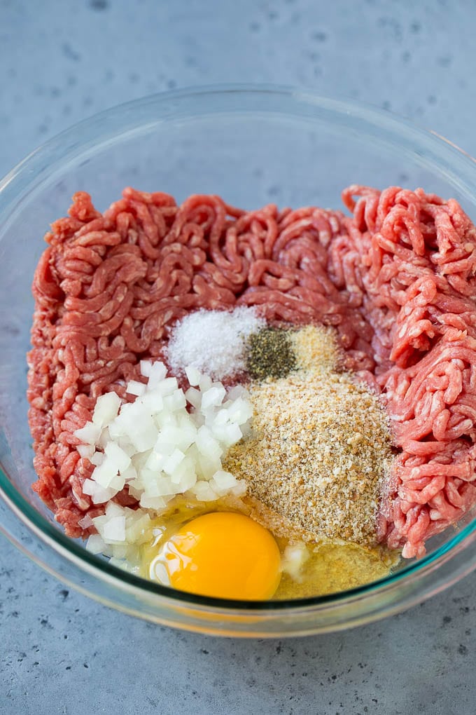 Sweet and Sour Meatballs Recipe | Slow Cooker Meatballs | Crockpot Meatballs | Cocktail Meatballs #meatballs #beef #slowcooker #crockpot #dinner #appetizer #fuyos Ground beef, onion, breadcrumbs and seasonings in a bowl.