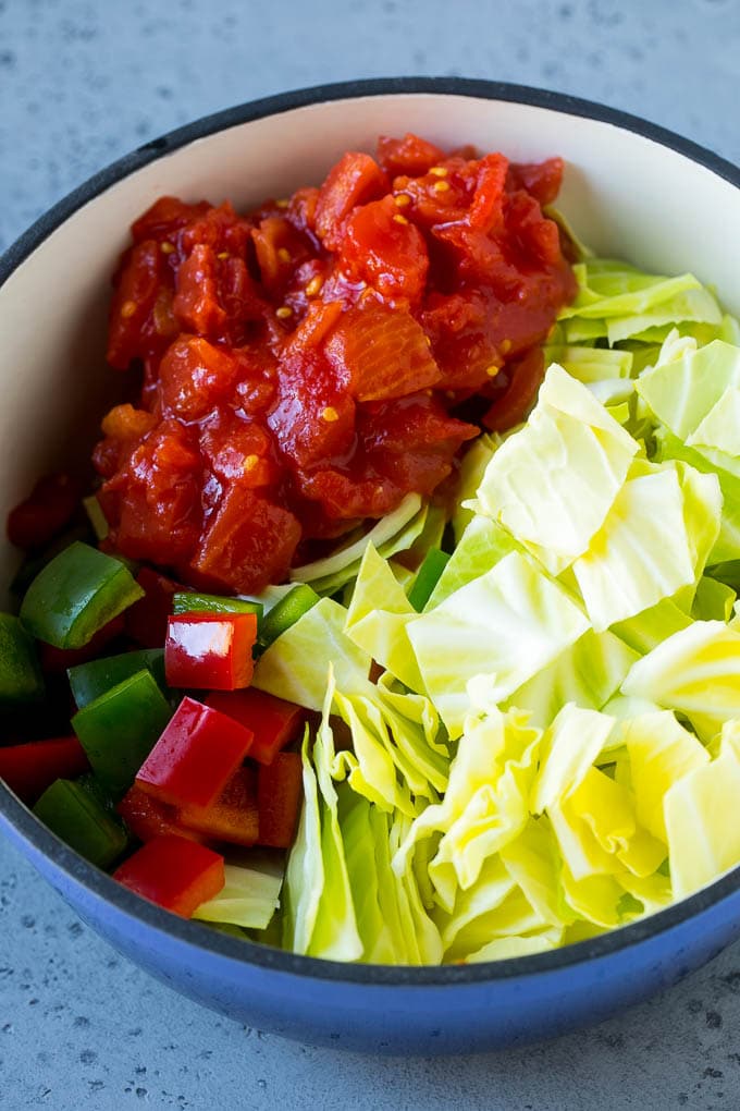 Cabbage Soup Recipe | Vegetable Soup | Veggie Soup | Healthy Soup #soup #healthy #cleaneating #cabbage #vegetables #veggies #dinner #fuyos Red and green peppers, diced tomatoes and raw veggies in a large pot.
