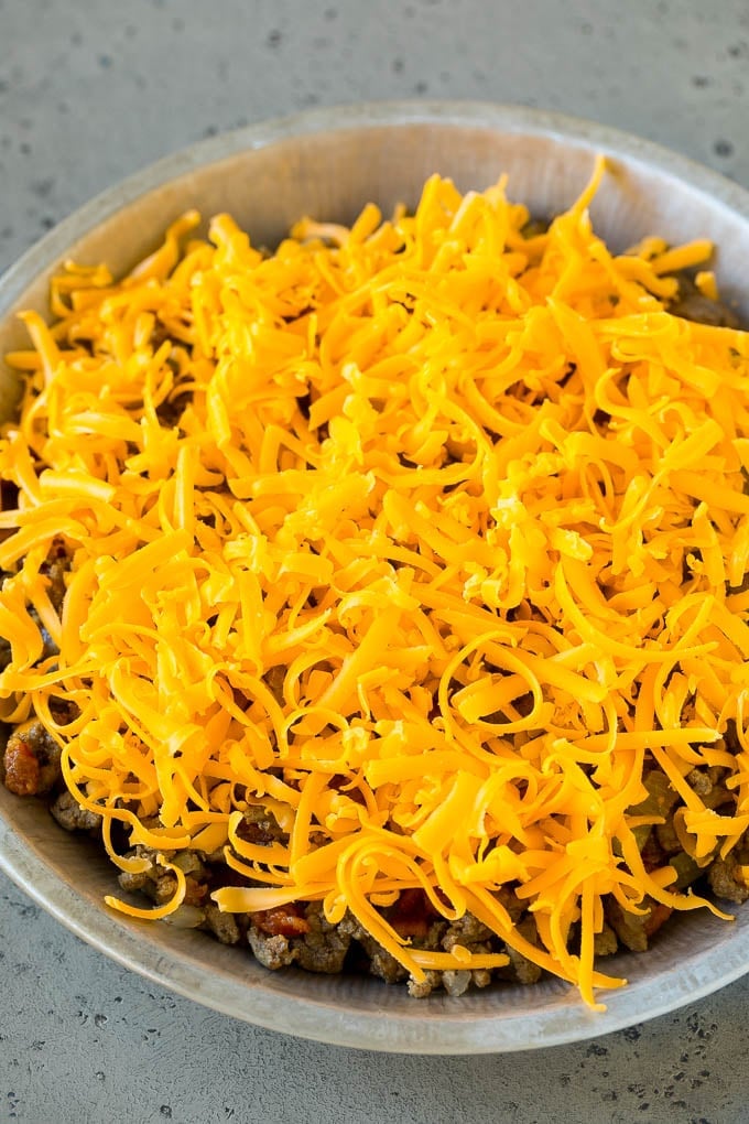 Ground beef and shredded cheddar cheese in a dish.