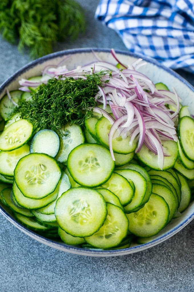 Creamy Cucumber Salad Recipe | German Cucumber Salad | Cucumber Salad #cucumber #salad #dinner #lunch #fuyos #cucumbersalad Thinly sliced cucumbers, red onion and fresh dill in a mixing bowl.