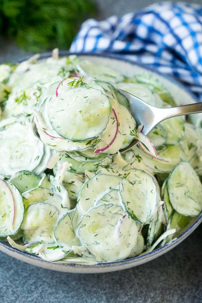 Creamy Cucumber Salad Recipe | German Cucumber Salad | Cucumber Salad #cucumber #salad #dinner #lunch #fuyos #cucumbersalad A spoon serving up a portion of creamy cucumber salad.