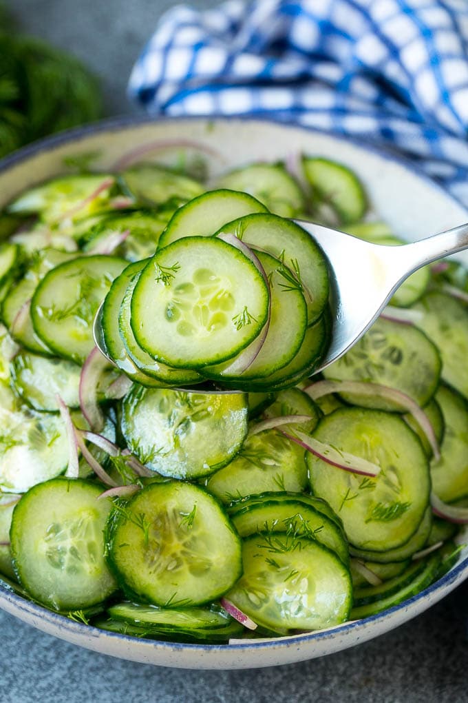 Cucumber Salad Recipe | Cucumber Dill Salad | Cucumber Recipe #cucumbers #salad #glutenfree #sidedish #fuyos A spoon serving up a portion of classic cucumber salad.