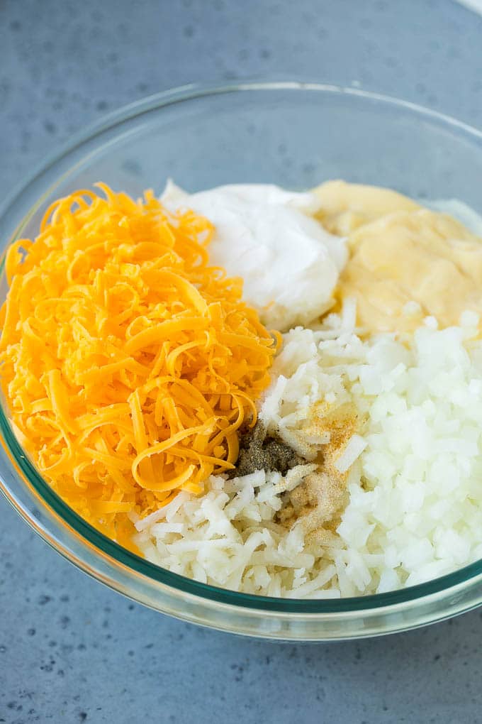 Hash Brown Casserole | Potato Casserole | Hash Brown Side Dish #potatoes #cheese #casserole #sidedish #fuyos A bowl of potato shreds, cheese, cream of chicken soup, sour cream and seasonings.