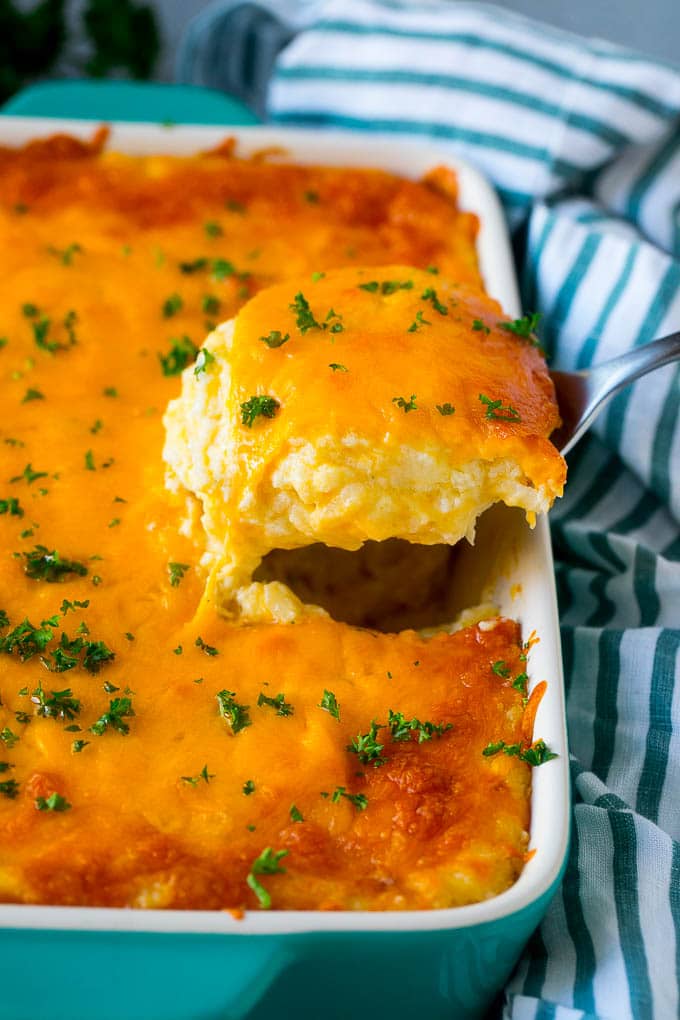 Hash Brown Casserole | Potato Casserole | Hash Brown Side Dish #potatoes #cheese #casserole #sidedish #fuyos A spatula pulling out a serving of cheesy hash brown casserole.