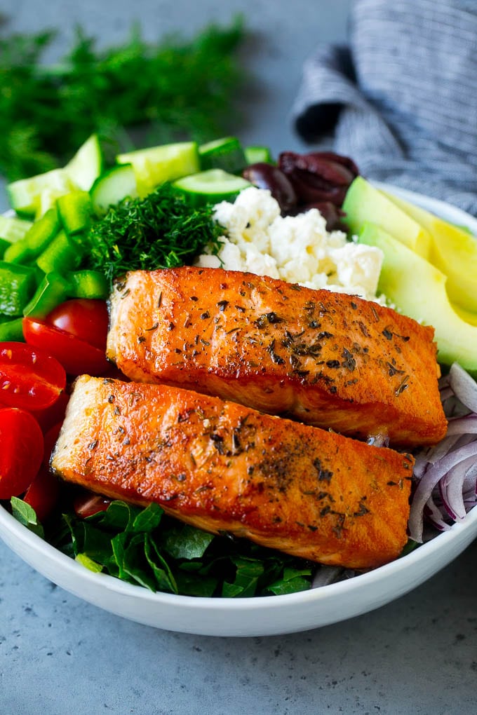 Greek Salmon Salad Recipe | Low Carb Salmon Recipe | Salmon Salad #salmon #seafood #fish #lowcarb #keto #lunch #fuyos #healthy Salmon fillets on lettuce with tomatoes, feta cheese, avocado, olives, cucumbers and herbs.