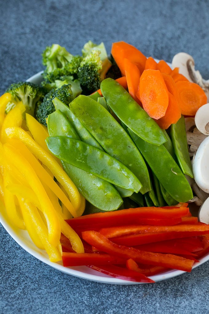 Vegetable Stir Fry Recipe | Veggie Stir Fry | Broccoli Stir Fry #vegetarian #vegetables #broccoli #dinner #fuyos Bell peppers, snow peas, carrots, mushrooms and broccoli on a plate.
