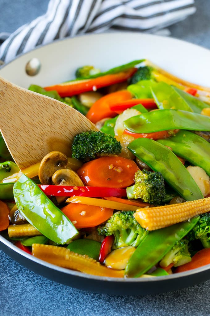 Vegetable Stir Fry Recipe | Veggie Stir Fry | Broccoli Stir Fry #vegetarian #vegetables #broccoli #dinner #fuyos A spatula in a pan of veggie stir fry with carrots, snow peas and broccoli.