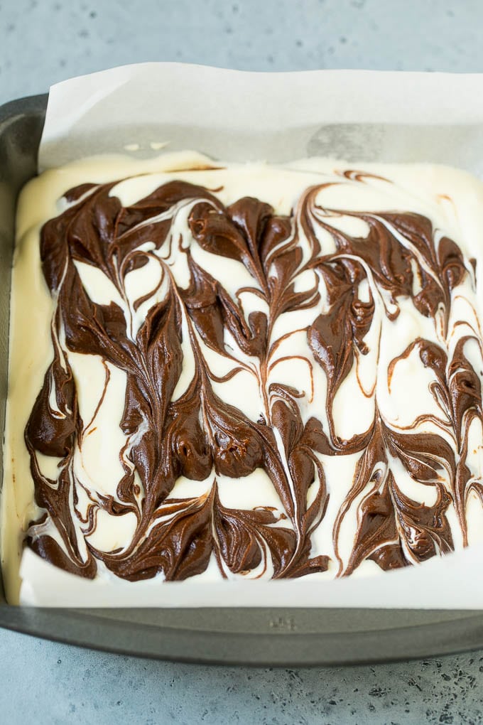 Cheesecake Brownies Recipe | Cream Cheese Brownies | Homemade Brownies #brownies #cheesecake #chocolate #dessert #fuyos Swirled chocolate and cream cheese brownie batters in a baking pan.