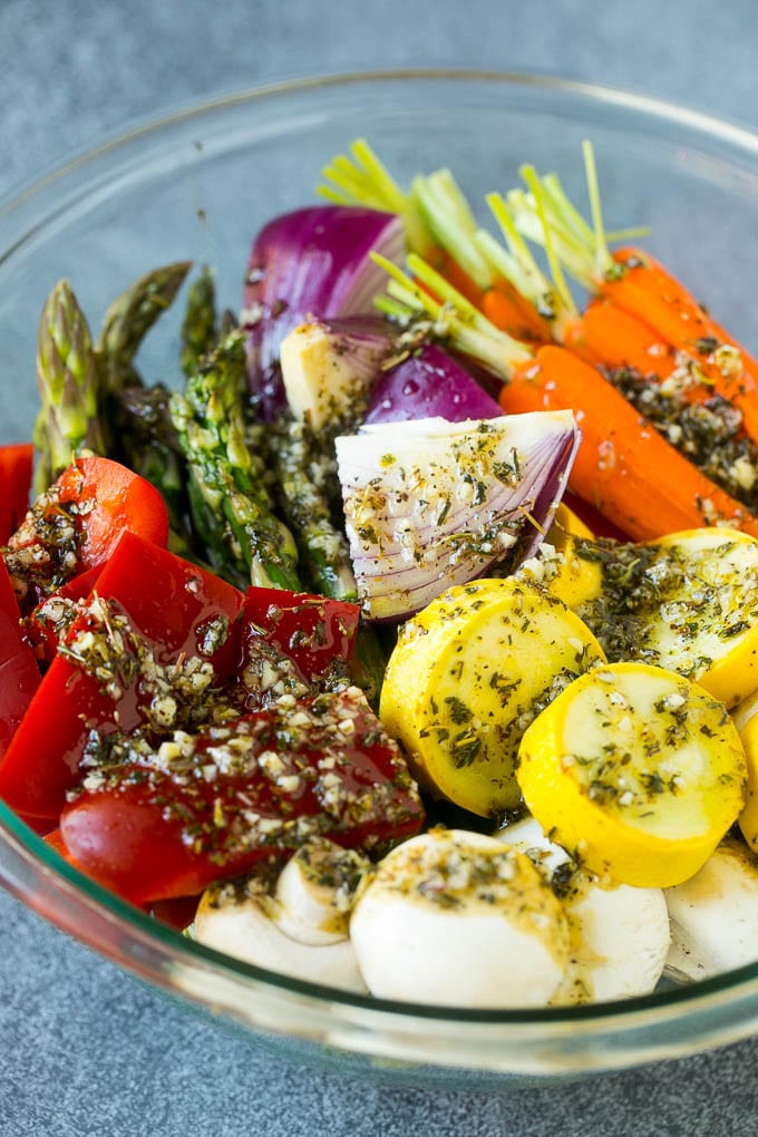 Raw veggies in a bowl with garlic, herbs and olive oil.