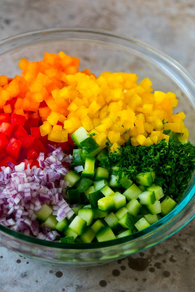 Israeli Salad Recipe | Cucumber Salad | Tomato Salad | Chopped Salad #salad #cleaneating #healthy #glutenfree #lowcarb #keto #sidedish #lunch #fuyos Chopped peppers, cucumbers, tomatoes and onions in a bowl.