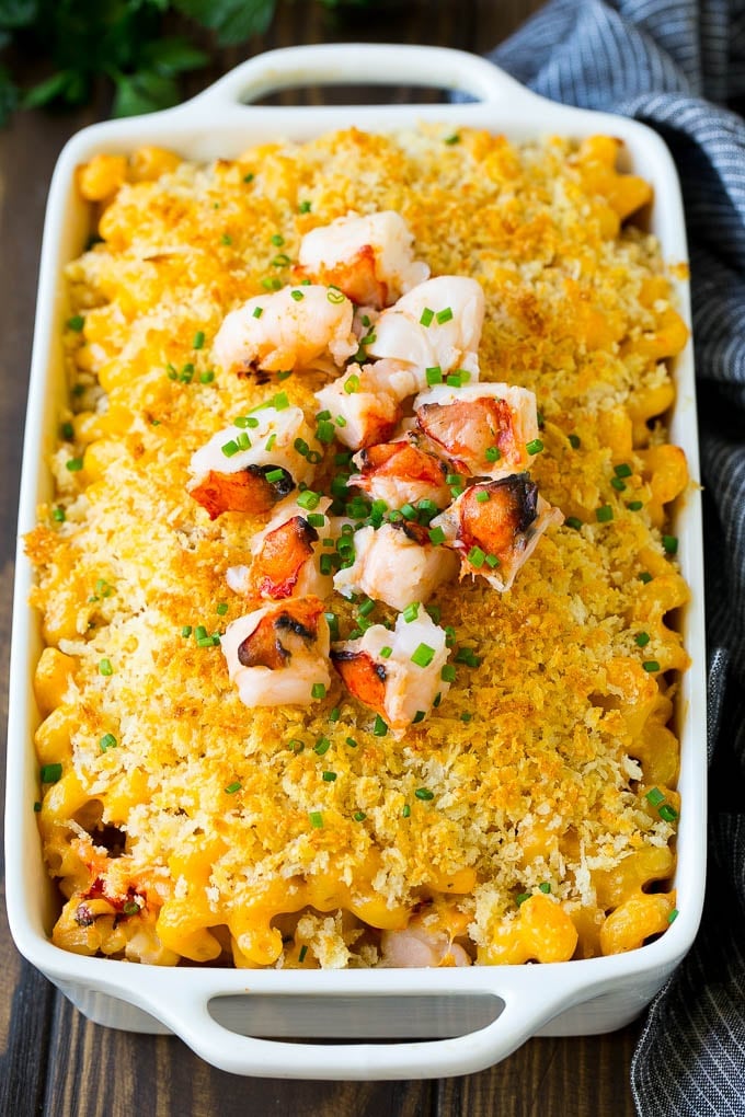 A baking dish of lobster macaroni and cheese, garnished with chopped lobster meat.