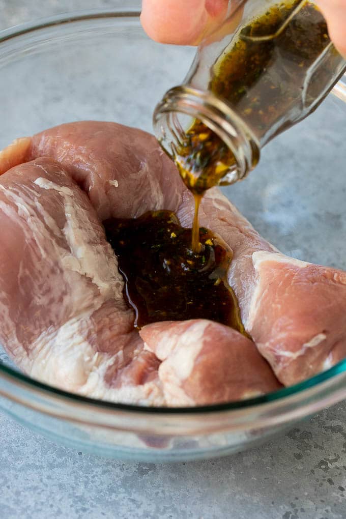 Marinated Pork Tenderloin Recipe | Pork Tenderloin Marinade | Pork Marinade #pork #porktenderloin #marinade #dinner #grilling #fuyos Marinade being poured over pork tenderloin.