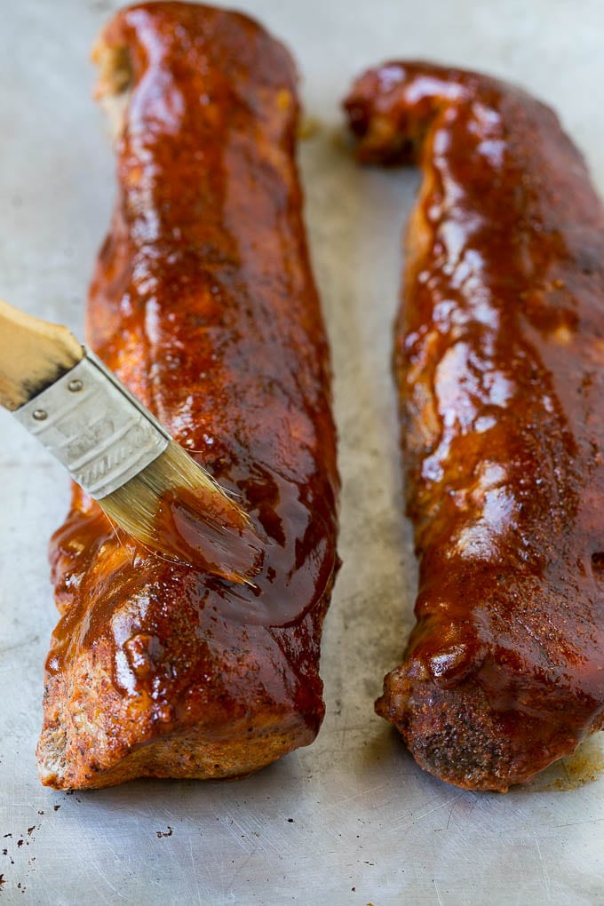 Smoked Pork Tenderloin Recipe | Smoked Pork Loin | BBQ Pork #pork #tenderloin #smoker #dinner #fuyos BBQ sauce being brushed over smoked pork loin.