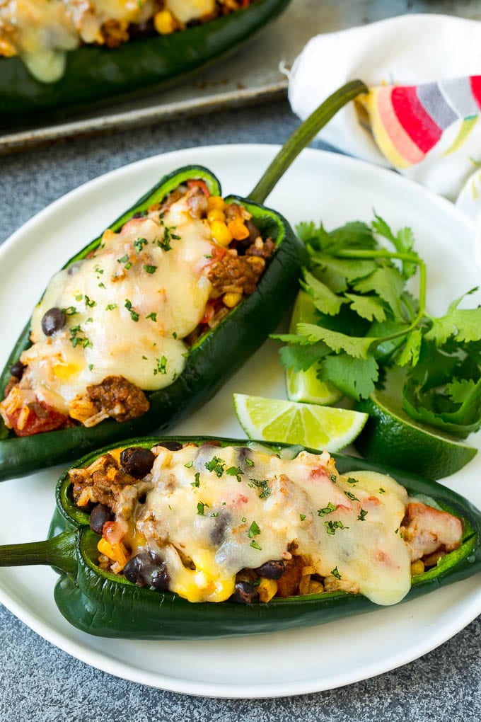 Stuffed Poblano Peppers | Stuffed Peppers | Pasilla Peppers #peppers #stuffedpeppers #beef #rice #beans #corn #dinner #fuyos A plate of stuffed poblano peppers topped with melted cheese.