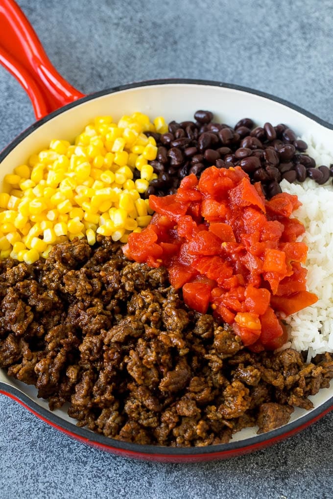 Stuffed Poblano Peppers | Stuffed Peppers | Pasilla Peppers #peppers #stuffedpeppers #beef #rice #beans #corn #dinner #fuyos A skillet filled with ground beef, rice, tomatoes, beans and corn.