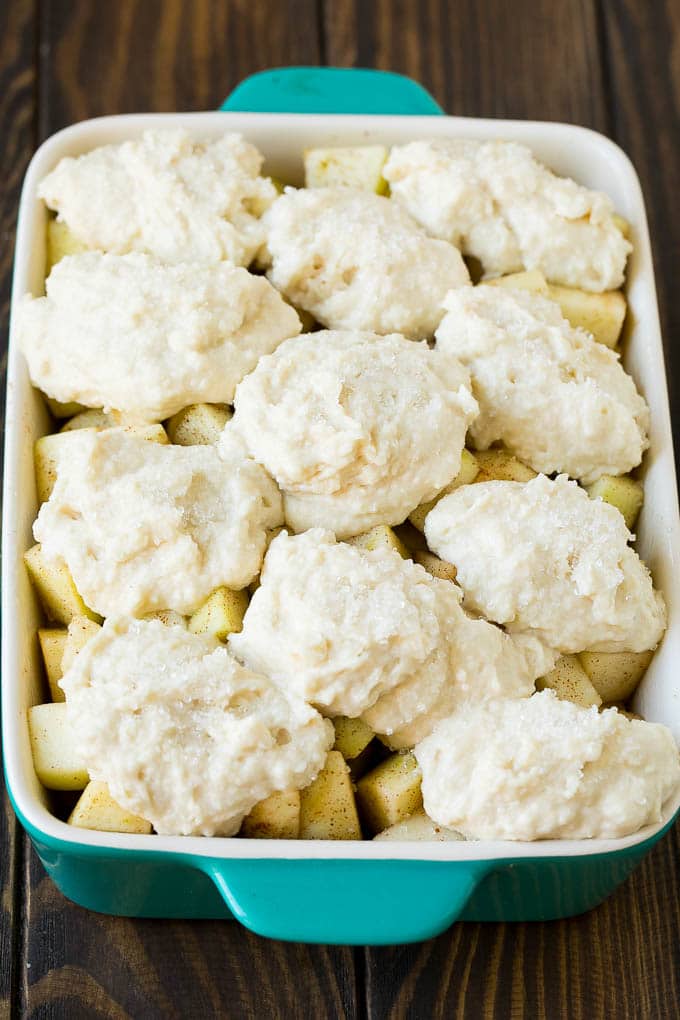 Apple Cobbler Recipe | Apple Dessert #apples #cobbler #dessert #baking #fall #fuyos Fruit in a baking dish with dough over the top.