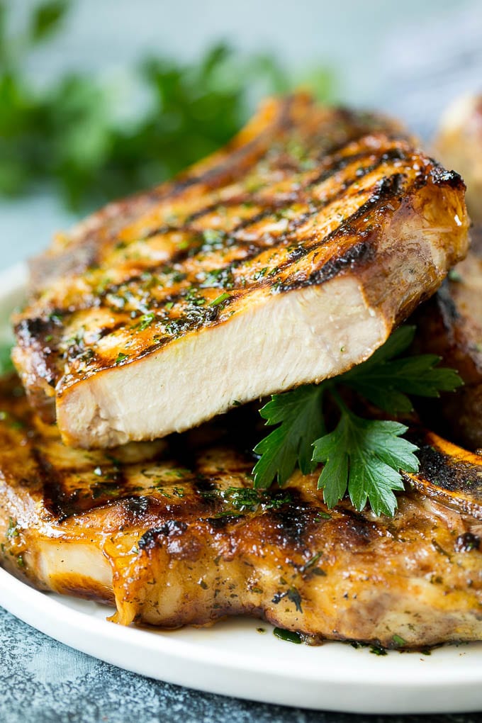 Grilled Pork Chops | Pork Chop Marinade #porkchops #grilling #pork #marinade #dinner #fuyos Grilled pork chops with a cut chop on top of the stack.