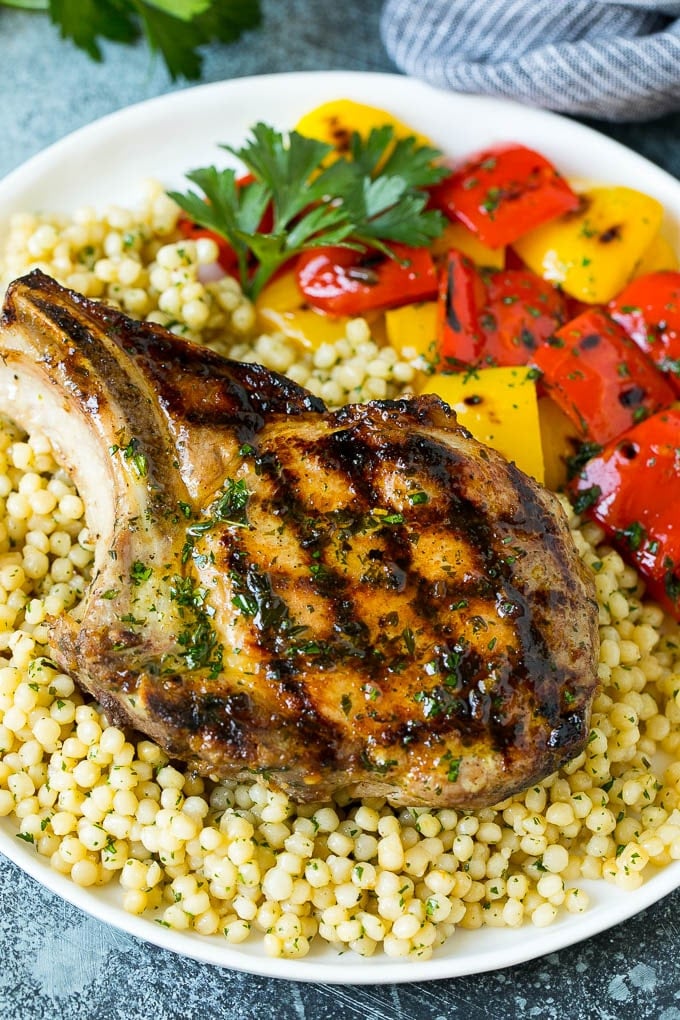 Grilled Pork Chops | Pork Chop Marinade #porkchops #grilling #pork #marinade #dinner #fuyos A grilled pork chop served over couscous with bell peppers on the side.