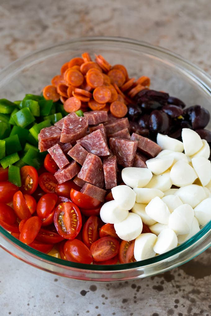 Italian Pasta Salad | Pasta Salad Recipe #pasta #salad #pastasalad #pepperoni #salami #olives #cheese #sidedish #fuyos A bowl of pasta, mozzarella balls, cherry tomatoes, bell peppers and olives.