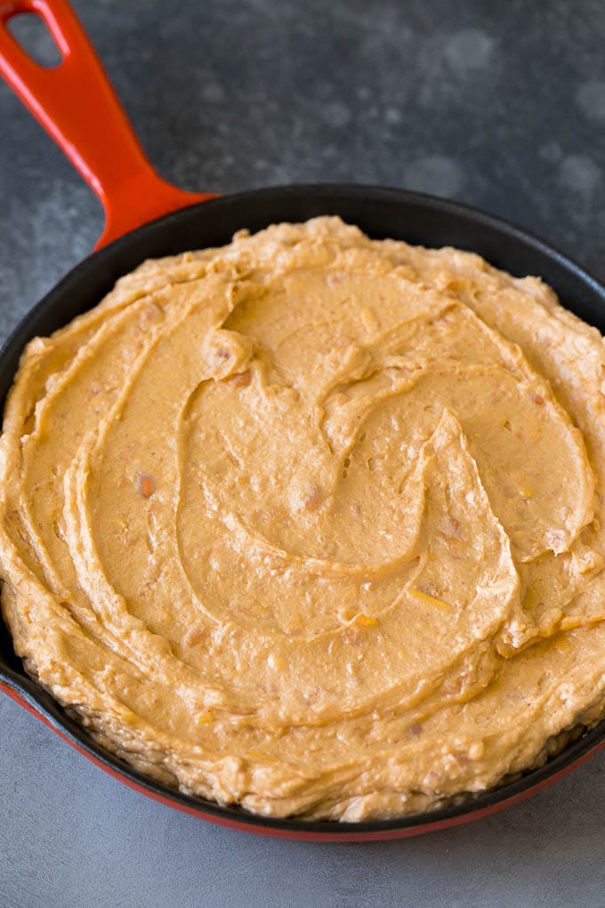 Bean Dip Recipe | Mexican Dip #dip #appetizer #mexicanfood #beans #cheese #fuyos Refried frijoles mixed with cream cheese, sour cream and seasonings in a skillet.