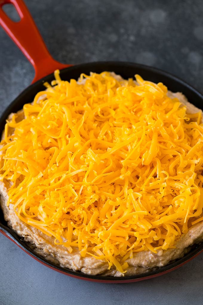 Bean Dip Recipe | Mexican Dip #dip #appetizer #mexicanfood #beans #cheese #fuyos The base topped with freshly shredded cheese.
