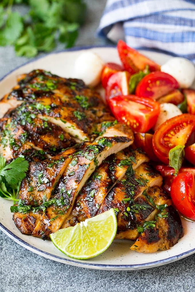 Grilled Chicken Thighs Recipe | Marinated Chicken Thighs #chicken #grilling #marinade #dinner #cilantro #lime #fuyos Sliced chicken thighs served with tomato salad.