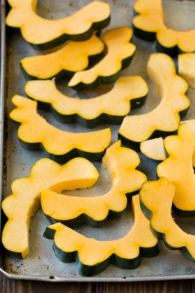 Roasted Acorn Squash | Acorn Squash Recipe #squash #winter #sidedish #dinner #fuyos Sliced acorn squash on a sheet pan.