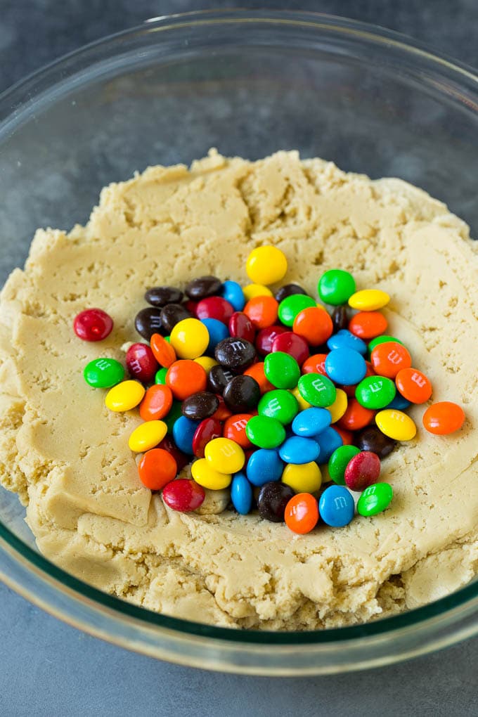 M&M Cookies Recipe #cookies #chocolate #baking #dessert #sweets #fuyos A bowl of cookie dough with chocolate candies in it.